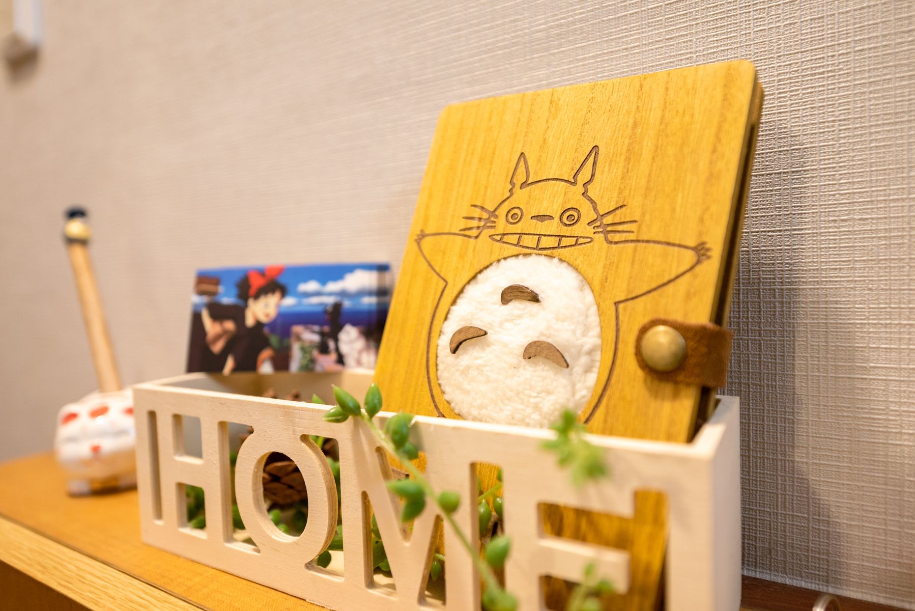 A wooden display with a cat figure and the word "HOME" on a shelf.