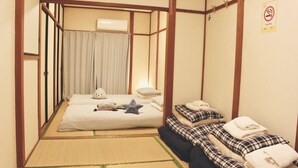 Habitació tradicional japonesa amb tatami, un llit fusuma i una petita taula de nit.