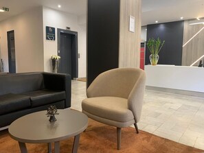 Relax in style with a black leather sofa, round table, and comfortable armchair in our elegant lobby.