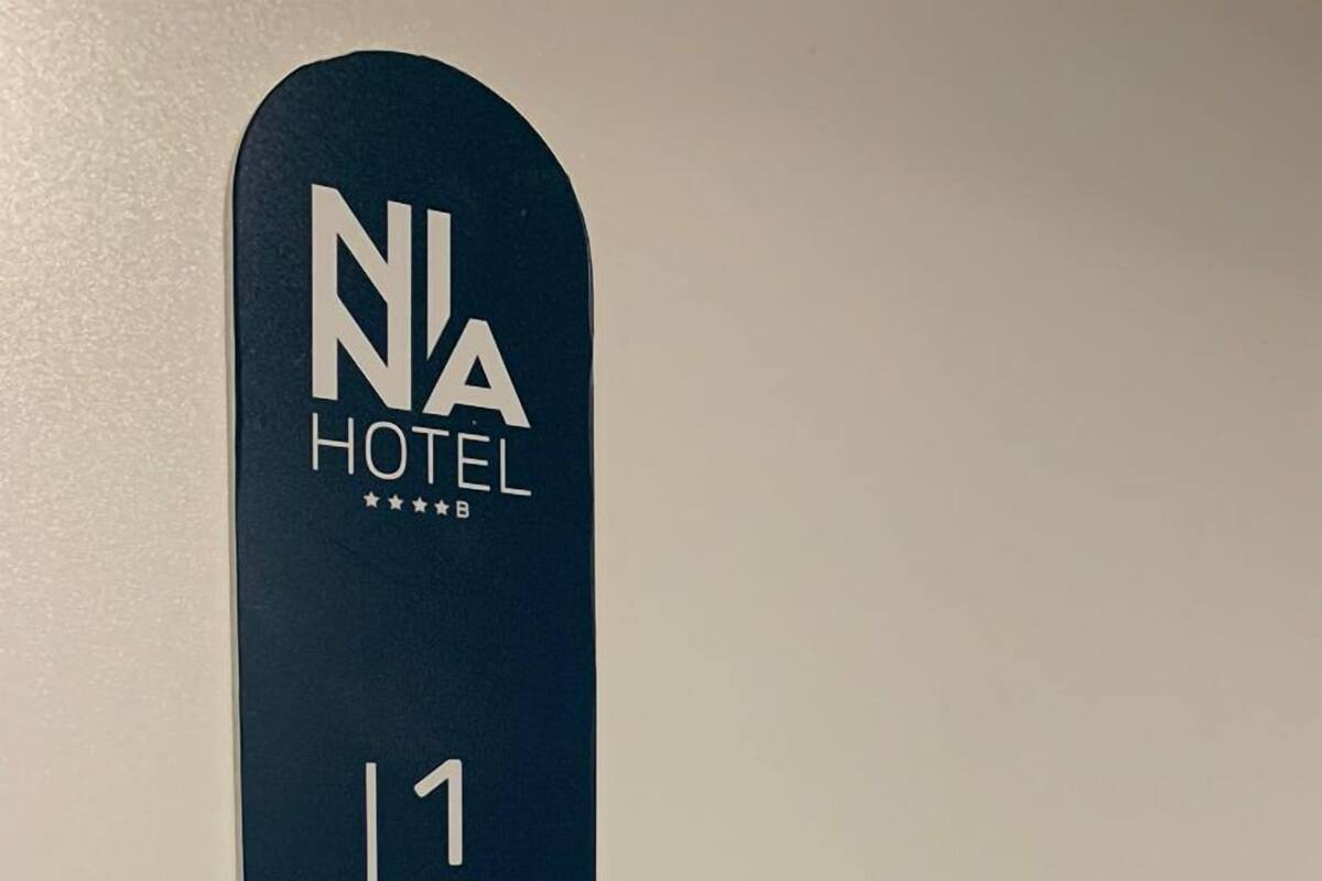 A hotel sign with the name "NA HOTEL" and the room number "103".