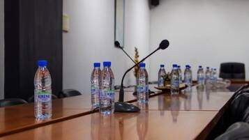 A conference table with water bottles labeled 'KIRENE' and a microphone.