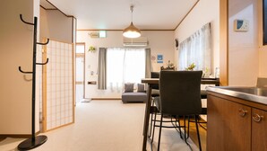 Une chambre d’hôtel moderne comprenant un coin repas, un canap é, une table basse et un comptoir de cuisine.