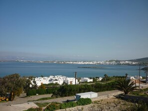 A coastal view with white buildings, a clear blue sky, and a calm sea. - Nikoleta Kolympithres Paros (Paros)
