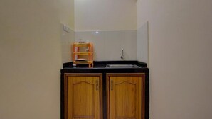Une petite salle de bain avec des meubles en bois, un plan de toilette noir et un miroir au-dessus du lavabo.