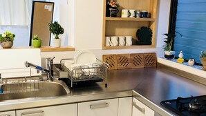 Een moderne keuken met witte kasten, een roestvrijstalen spoelbak en een ingebouwde kookplaat.