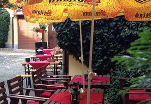 Dine under the shade of yellow umbrellas, surrounded by lush greenery and a serene water view.