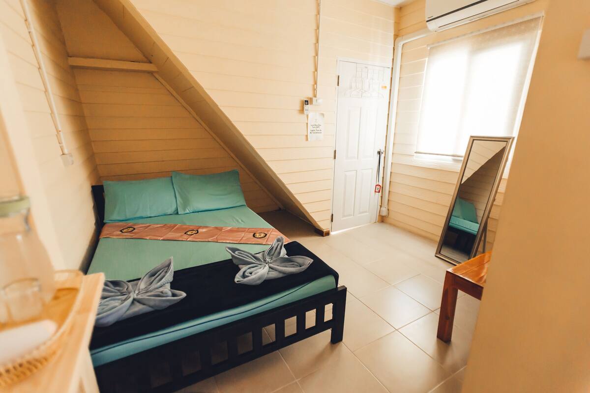 Een slaapkamer met een bed, een spiegel, een deur en een raam.