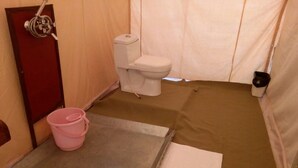 A small, compact bathroom with a toilet, a shower area, and a sink. - TSI Kumbh Mela Camp (Prayagraj)