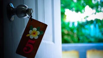 Uma porta com uma placa de identificação com o número 5 e um chaveiro com uma flor.