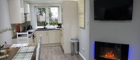 Deluxe-Apartment, Mehrere Betten, Nichtraucher, Gartenblick | Wohnzimmer | 42-Zoll-Flachbildfernseher mit Kabelempfang, Smart-TV, Kamin