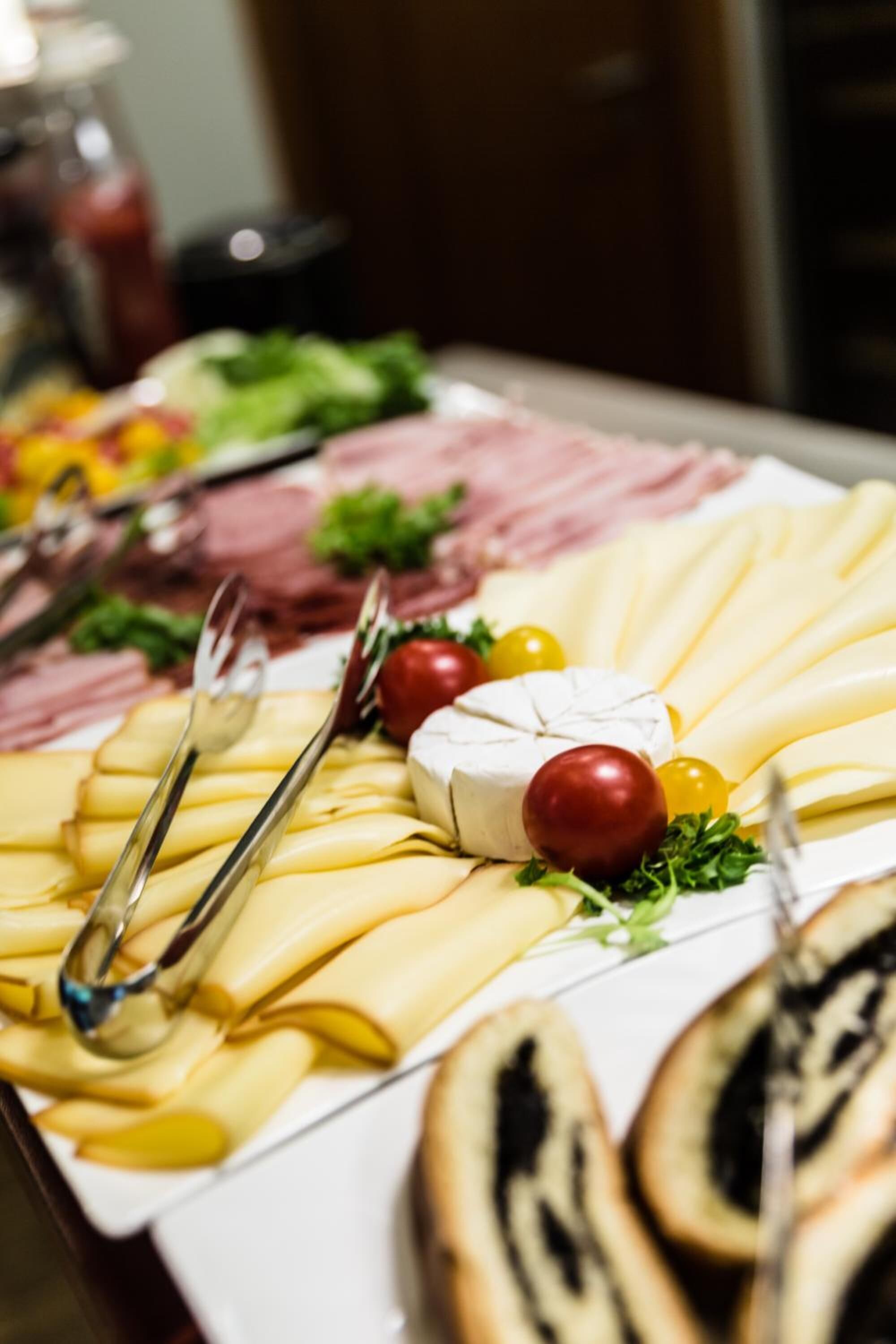 A charcuterie board with various cheeses, meats, and fruits.