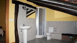 Une salle de bain avec un lavabo, des toilettes et une douche.