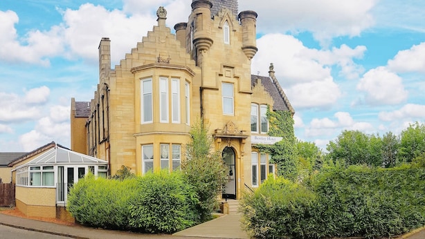 A historic building with a prominent tower, bay windows, and a sign for the Bentley Hotel. - Bentley Hotel (Motherwell)