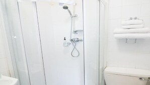A bathroom with a glass-enclosed shower, a toilet, and a sink. - Bentley Hotel (Motherwell)