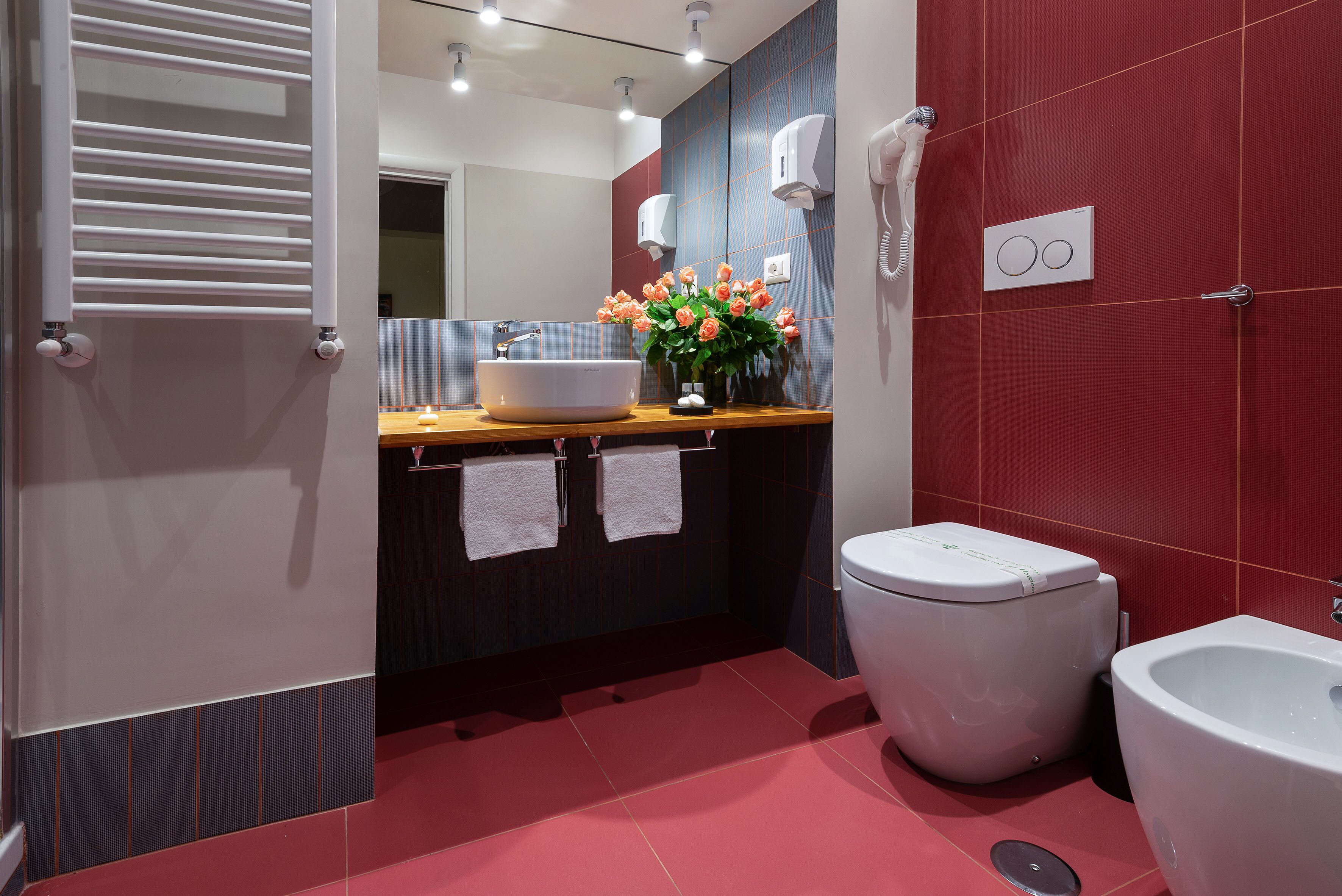 Un baño moderno con un lavamanos grande, un inodoro, un bidé y un espejo.
