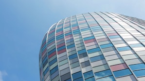 A tall, modern building with a curved facade and a grid of windows. - Hampton by Hilton Utrecht Central Station (Utrecht)