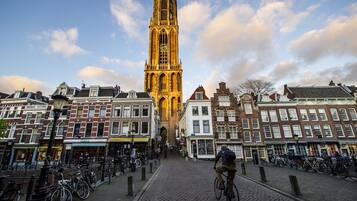 Een historisch gebouw met een hoge toren, omgeven door kinderaars en fietsen.