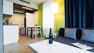 Un salon moderne avec une table basse blanche, un canapé et un coin repas comprenant une table et des chaises.