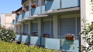 Un immeuble à plusieurs étages doté de balcons, chacun orné de plantes en pot.