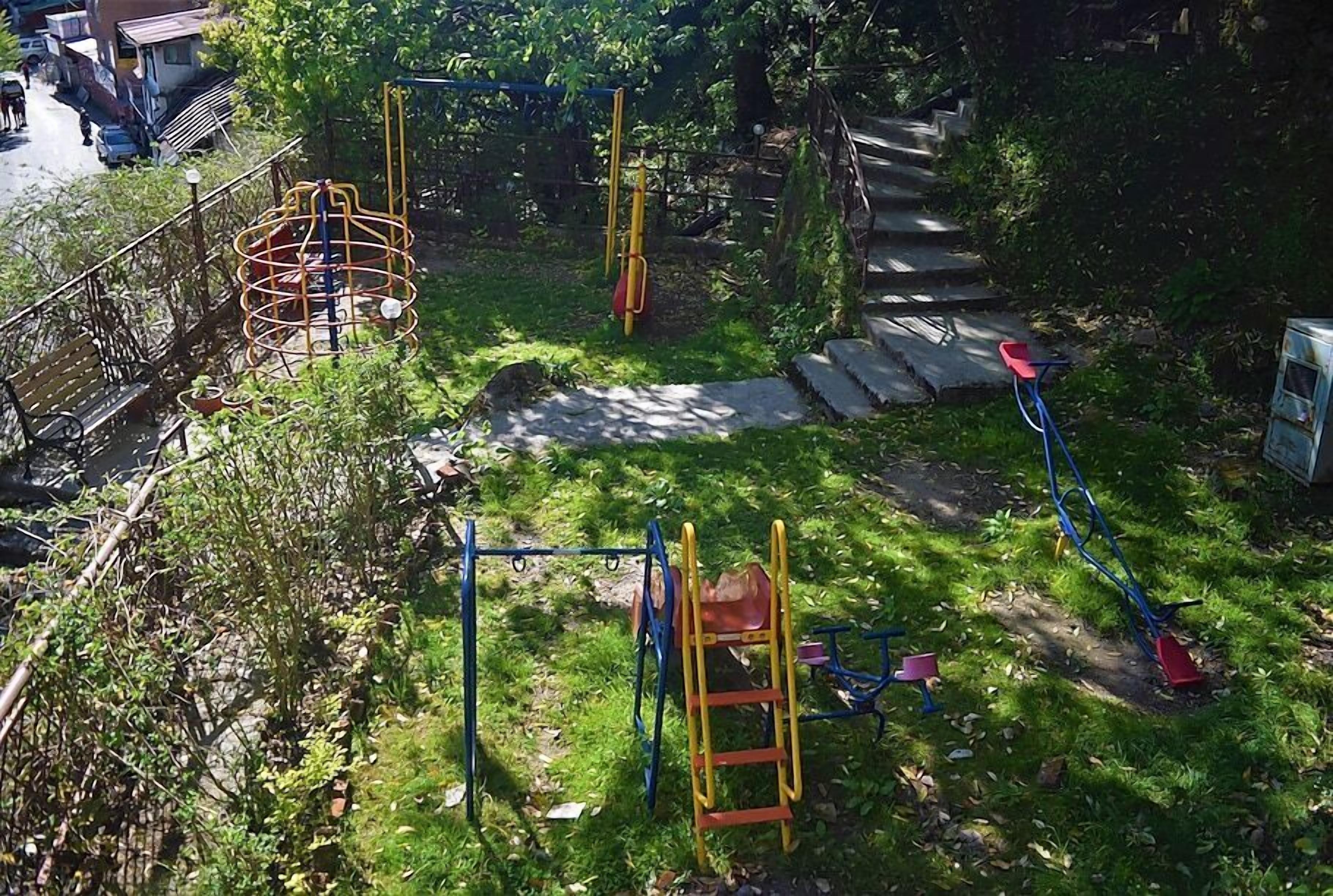 Un parque infantil con diferentes estructuras de juego, como columpios, un rocódromo y un tobogán.