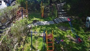 Un parque infantil con diferentes estructuras de juego, como columpios, un rocódromo y un tobogán.