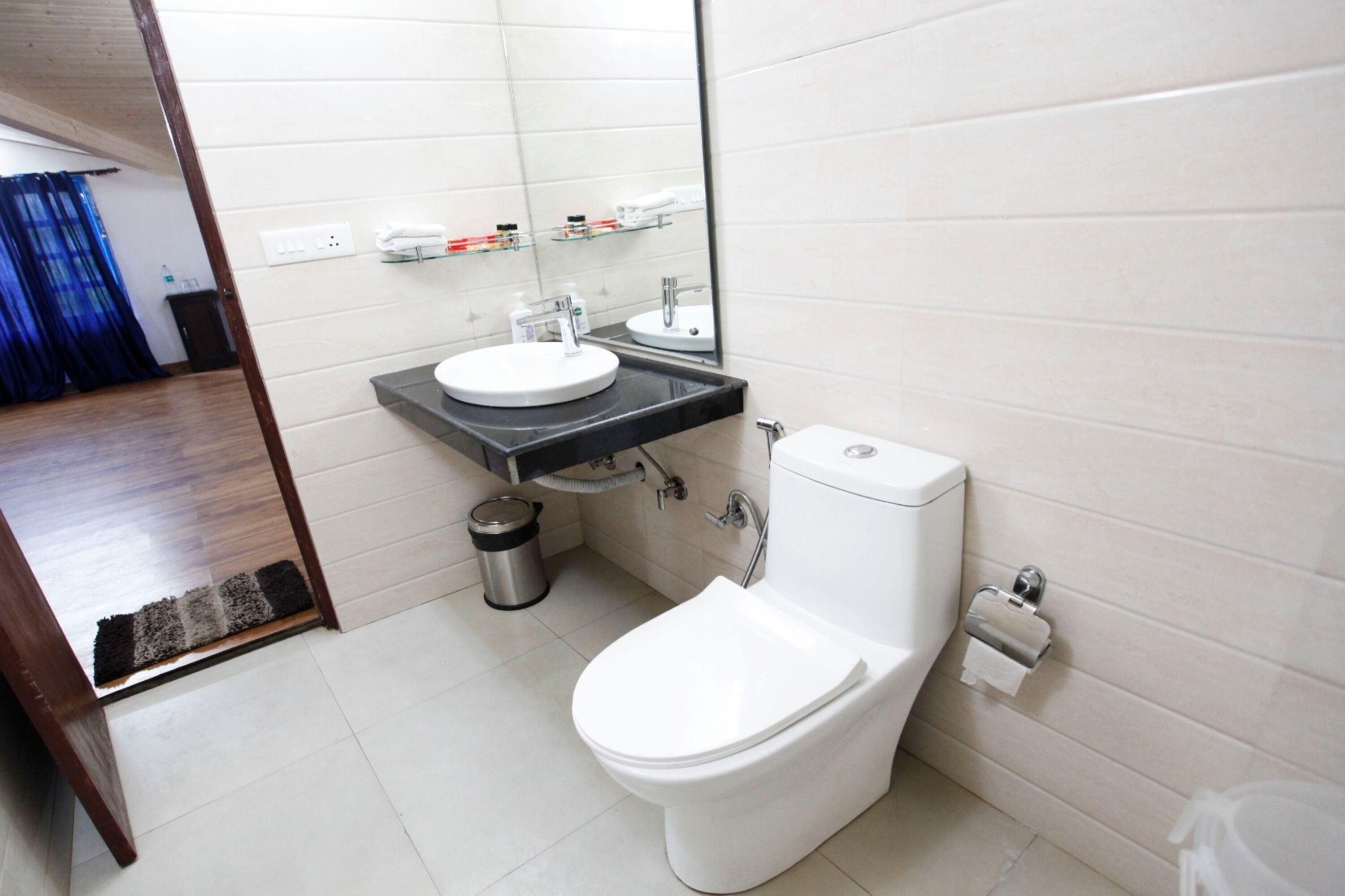 A modern bathroom with a toilet, sink, and mirror.