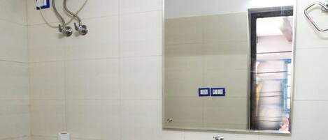 Un baño con inodoro, lavabo, espejo y secamanos.
