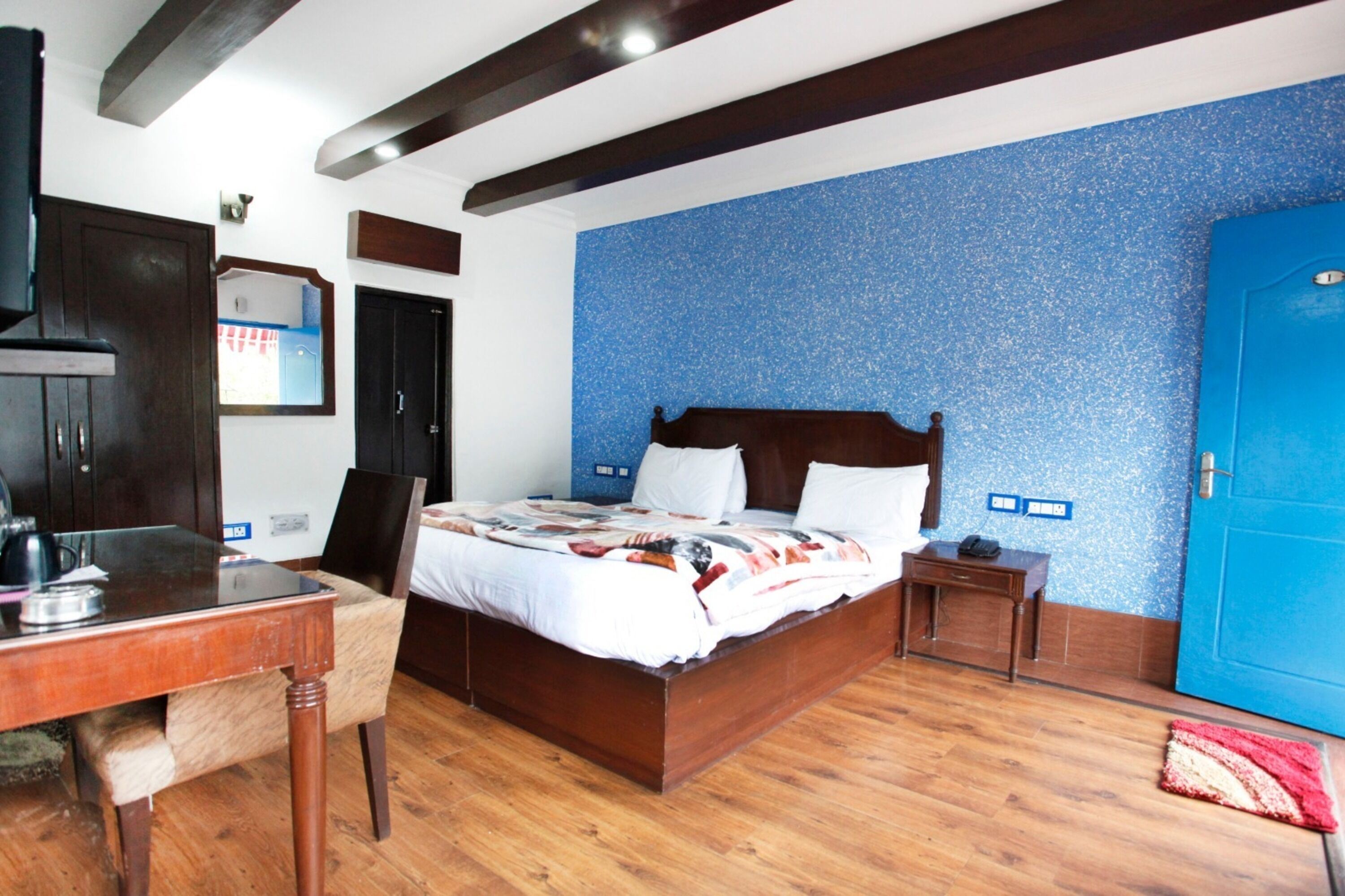 A bedroom with a wooden bed, a desk, and a chair.