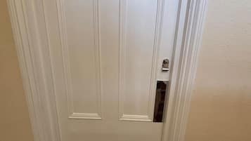 A white door with the number 1, a doorbell, and a doormat with "GMH" on it.