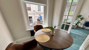 A dining area with a round table, two chairs, and a small plant on the table. - Great Malvern Hotel (Malvern)