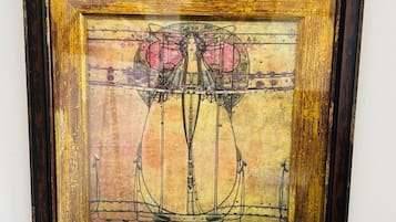 A framed artwork with a geometric design and floral elements.