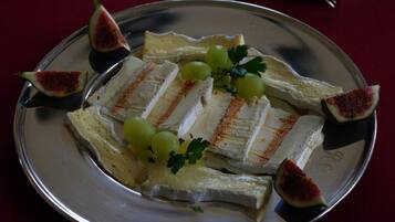 Una bandeja plateada con queso, higos y uvas.