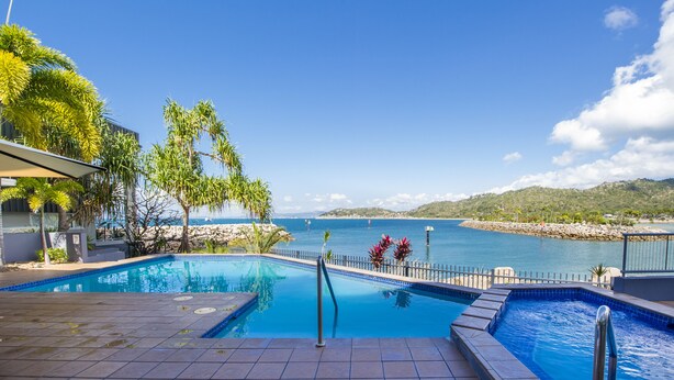 Una piscina con vistas al mar y a las montañas.