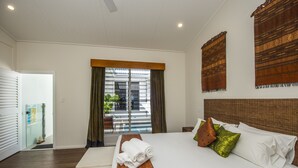 A hotel room with a large bed, a window with curtains, and a view of the outside.