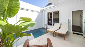 A modern outdoor pool area with a clear blue sky, a white exterior, and a lounge chair. - Reflections Villa 4 (Picnic Bay)