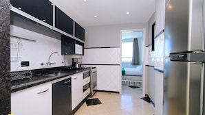 A modern kitchen with a stainless steel refrigerator, a microwave, and a coffee maker on the countertop. - MZapartments Bolivar Penthouse (Rio de Janeiro)
