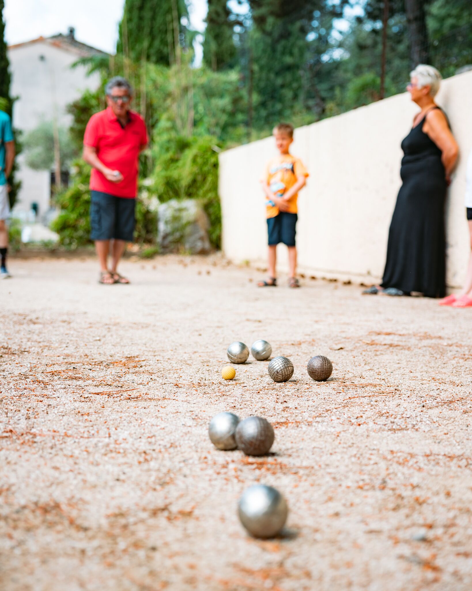 Un gros plan d’une partie de croquet, avec des balles sur une surface sablonneuse.