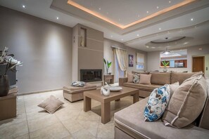 Villa, privézwembad | Woonkamer | Flatscreentelevisie en een open haard