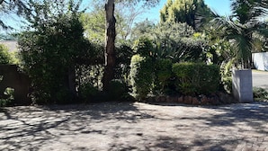 A paved driveway leading to a gated entrance with a white wall and the number 482. - KaRwizi  (Harare)