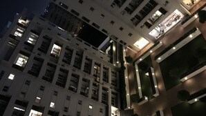 Hotel de diverses plantes amb finestres il·luminades i una zona d'entrada ben il·luminada.
