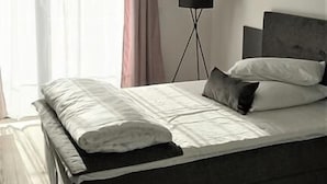 Una camera da letto moderna con un letto grande, una lampada da terra e un quadro appeso al muro.