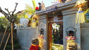 A temple entrance with a sign, two lion statues, and decorative elements. - Pondok DD Canggu (Canggu)