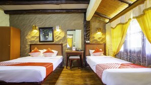 A hotel room with two single beds, a wooden desk, and a mirror. - Capital O 2640 Rumah Kayu Cottage Syariah (Parongpong)