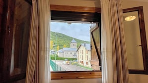 A room with a window overlooking a street and a hill. - Apartamentos Gavín Biescas 3000 (Biescas)