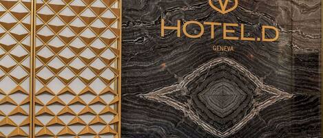 A hotel interior with a geometric patterned wall and a marble-like textured wall.
