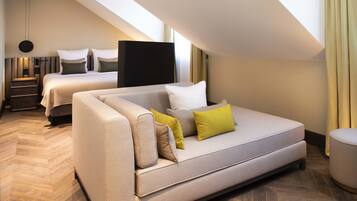 Una habitación de hotel moderna con una cama grande, un sofá y un escritorio.