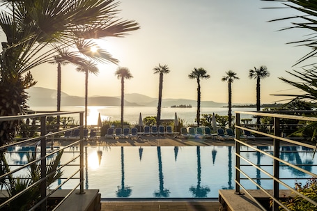 Una piscina al aire libre, sombrillas, sillones reclinables de piscina. Onda Blu Resort