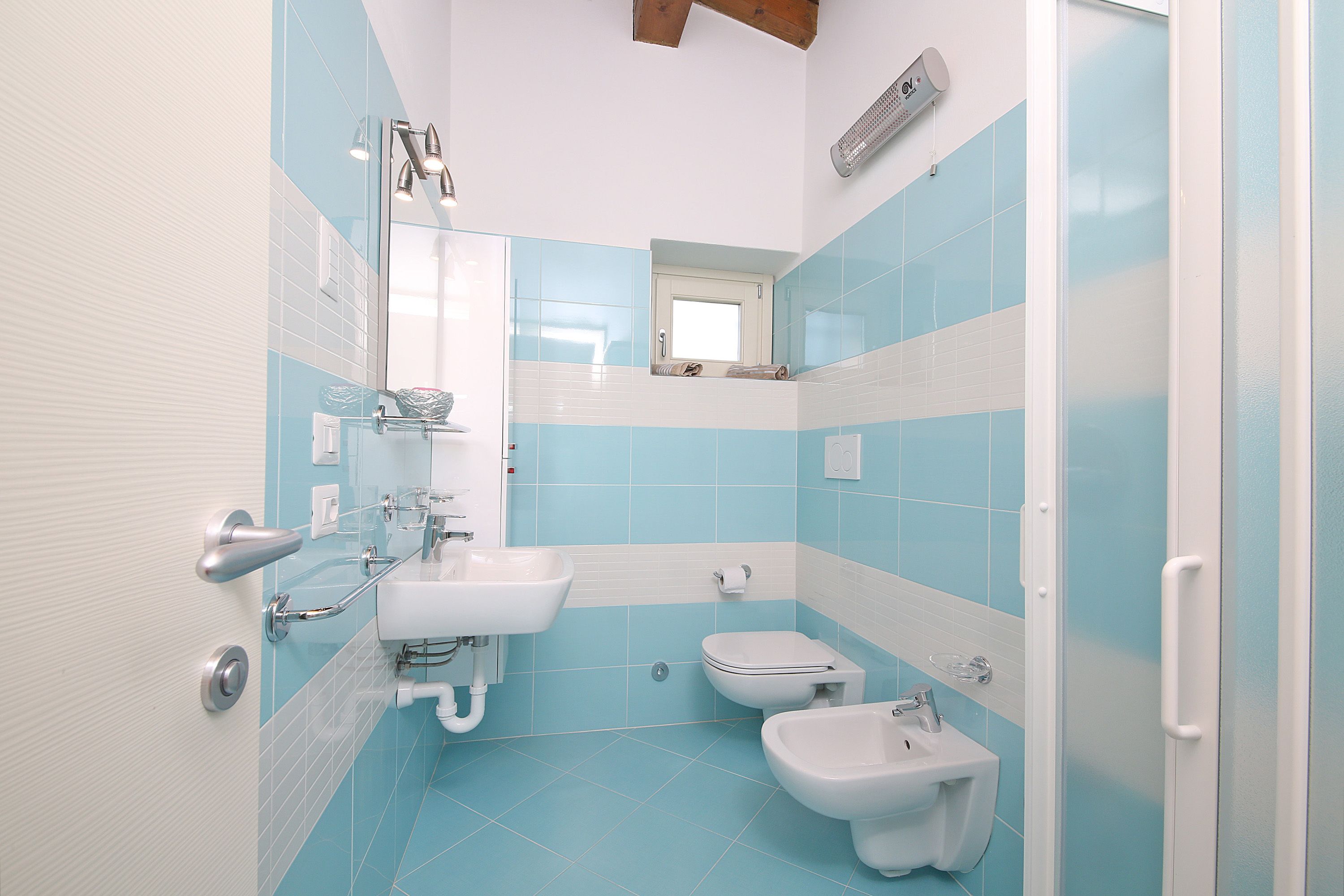 Ein Badezimmer mit Dusche, Waschbecken, Toilette und Bidet.