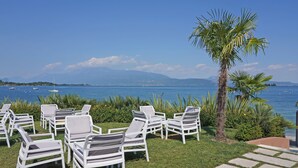 Terrasse extérieure avec vue sur la mer et les montagnes.