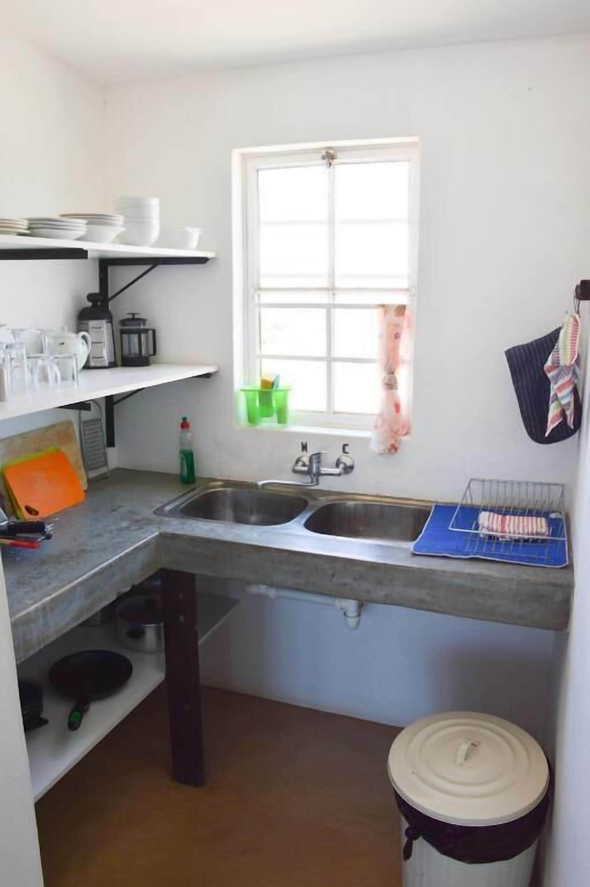 Una cocina compacta con ventana, un lavamanos y una encimera.